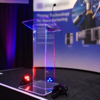Clear acrylic podium with gooseneck microphone on a stage